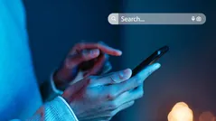 Person using a smartphone with a search bar illustrating SEO services