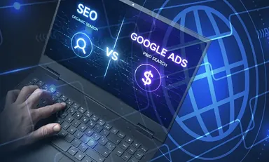 Laptop screen showing SEO versus Google Ads (paid search) graphic with a hand on the keyboard