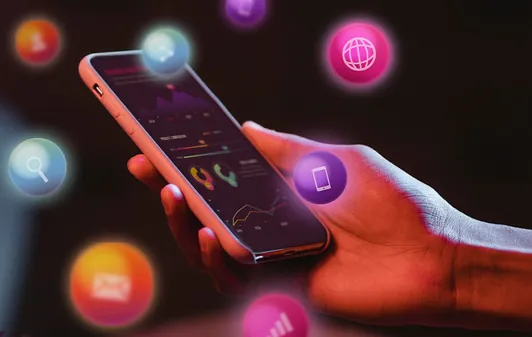 Smartphone held in hand showing analytics dashboard surrounded by glowing search, web, email and chat icons